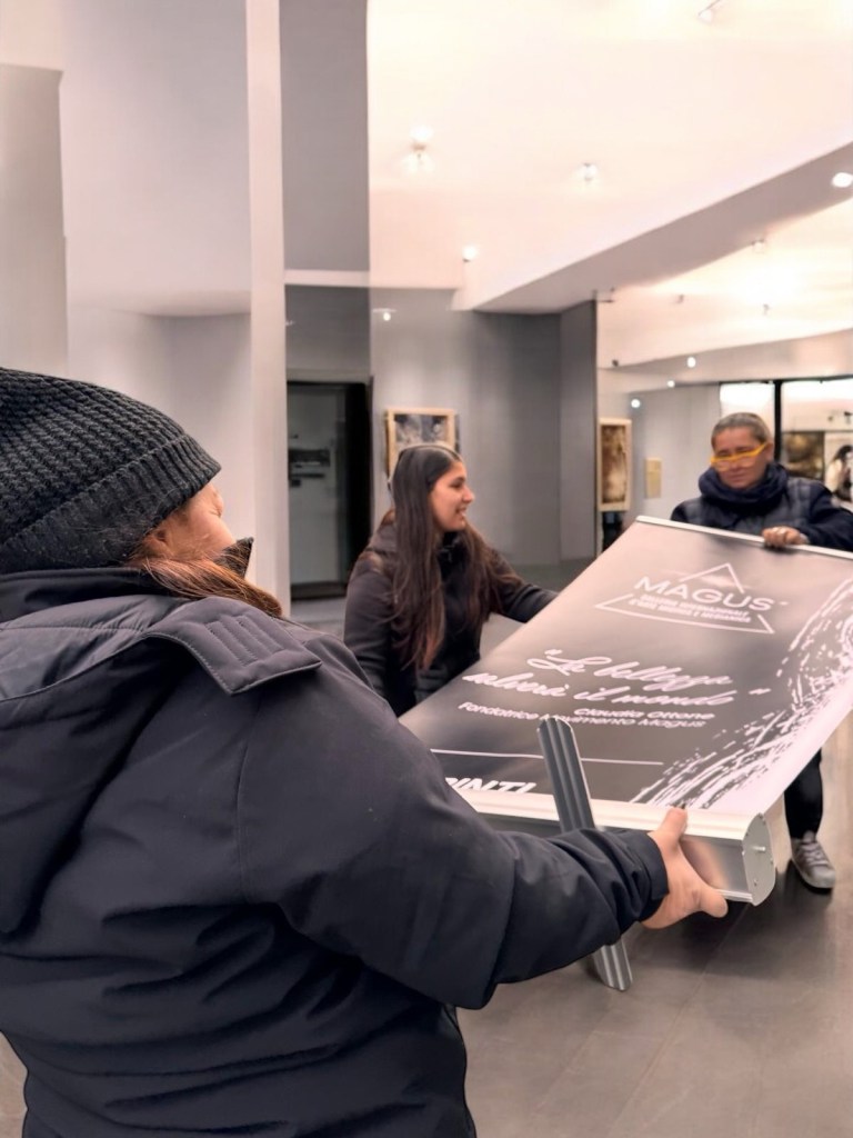 Team al lavoro mentre posiziona un roll-up della Galleria Magus durante l’allestimento di Medium Art Experience.